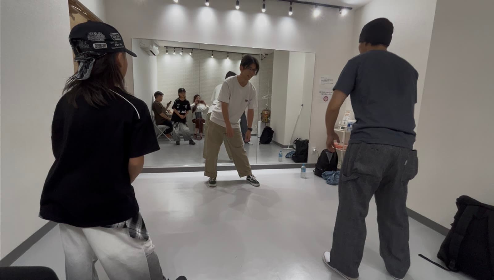 レッスン中、講師が受講者の前でポッピングの動きを実演している様子